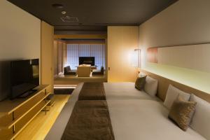 京都hotel kanra kyoto的一间配备有沙发及电视的酒店客房