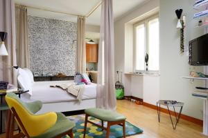 米兰黛乐西塔住宿酒店的卧室配有床、椅子和窗户。