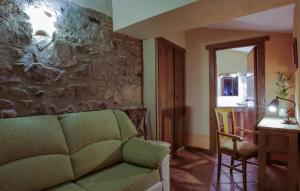 纳瓦斯-德尔马德罗尼奥Casa Rural La Chimenea的客厅设有绿色沙发和石墙