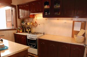 塔拉法尔Private Holiday Apartment的厨房配有木制橱柜和炉灶烤箱。