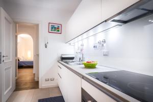 科莫Como Design Apartment - byMyHomeinComo的厨房配有白色橱柜和台面