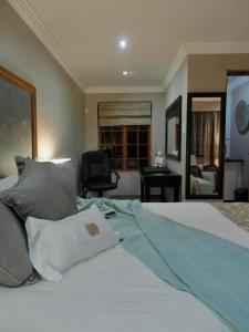 约翰内斯堡2扇门旅馆的一间卧室配有带白色床单和枕头的床。