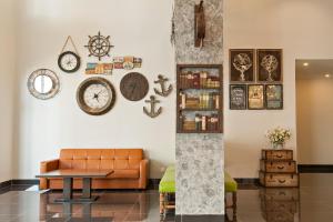 马六甲冠晶酒店的客厅配有沙发和墙上的时钟