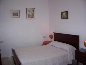 Castaño de RobledoCasa Amigo的卧室配有一张床,墙上挂有两张照片