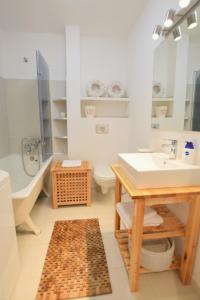 华沙Quantic Apartment的一间带水槽、浴缸和卫生间的浴室