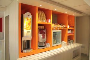 苏瓦松普瑞米尔索阿森经典酒店的厨房配有带咖啡机的橙色橱柜