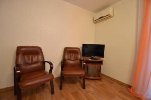 尼古拉耶夫Apartment on Navarynska的一间设有两把椅子、一台电视和一张桌子的房间