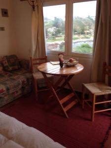 埃尔基斯科Turquesa的客房设有桌子、椅子和窗户。