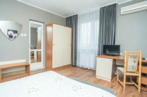 RazgradFamily Hotel Accent的一间卧室配有一张床、一张书桌和一台电视