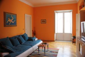 巴勒莫La Loggia del Marchese的客厅设有橙色墙壁和蓝色沙发