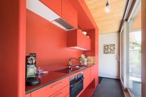 伯尔尼伊尔库博公寓的一间厨房,里面设有红色的墙壁和水槽