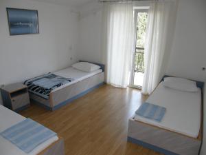 克勒克Guest House & Restaurant Adriatic Klek的一间卧室设有两张床,窗户设有阳台
