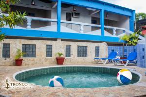 博卡奇卡Hotel El Tronco Inc的大楼前的带沙滩球的游泳池