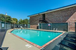 查塔努加Motel 6-East Ridge, TN的砖砌建筑前的带椅子的游泳池