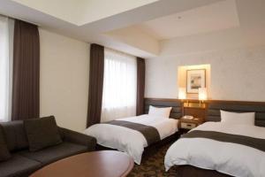 春日井胜川广场酒店的酒店客房,设有两张床和一张沙发