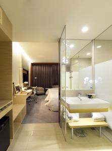 台南荣美金郁金香酒店的一间带水槽的浴室和一间带床的房间