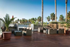 蒙特西尔瓦诺海狮酒店的露台配有椅子和棕榈树,甲板上