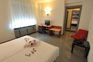基亚索班霍夫豪斯酒店的客房设有一张床和一张带红色椅子的书桌