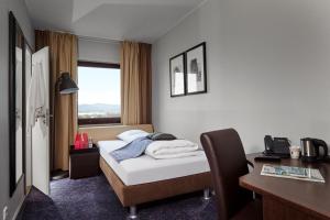 瓦埃勒瓦埃勒卡本酒店的配有一张床、一张书桌和一扇窗户的酒店客房