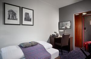 瓦埃勒瓦埃勒卡本酒店的一间卧室配有一张床和一张桌子及椅子