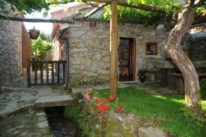 SobredoCasinhas da Levada的一座老石头房子,在院子里种花