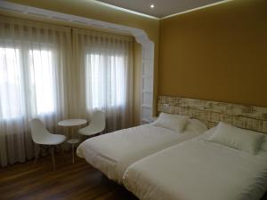 布尔戈斯Urban Burgos的卧室配有一张床和一张桌子及椅子