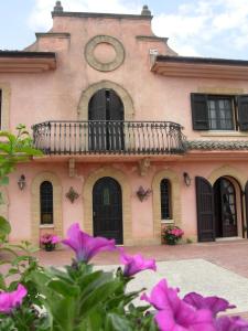 皮亚扎-阿尔梅里纳克莱门汀别墅 的粉红色的建筑,设有阳台和一些鲜花