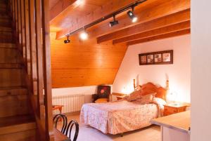 莱斯Ostau dera nheu的一间带一张床的卧室,位于带木制天花板的房间内