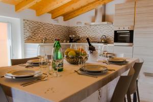 韦尔卡纳Villa Perla del Lago的厨房配有带酒瓶和玻璃杯的桌子