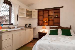 昆卡昆卡厄瓜多尔奥拓罗格公寓式酒店的一间卧室配有一张床,厨房配有水槽