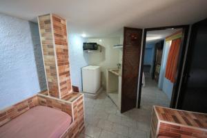 巴哈古拉提巴Pousada do Sergio的一间小房间,设有砖砌壁炉和一间浴室