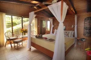马太椰林海滨小屋度假村的一间卧室配有一张带天蓬的床