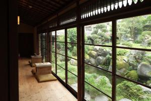 富山越中八尾基地小吃旅馆的客房设有大窗户,俯瞰着花园