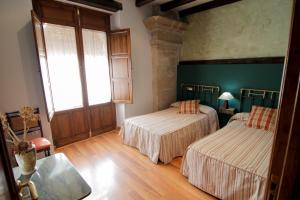 乌贝达Vivienda Turística Yamaries的配有绿色墙壁和木地板的客房内的两张床