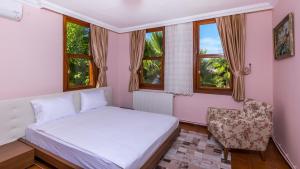 马尔马里斯Marmaris Holiday Villas的一间卧室配有一张床、一把椅子和窗户。