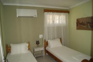 卡拉米Garneli Apartments的小型客房 - 带2张床和窗户