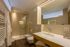 卢塔戈Appartement Hotel Erlhof Deluxe的一间带水槽、卫生间和镜子的浴室