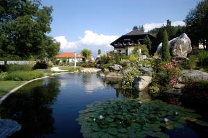 塞博登施泰纳西酒店的花园中的池塘,后面有房子