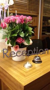 贝鲁特焦糖精品酒店的一张桌子上方的粉红色玫瑰花瓶