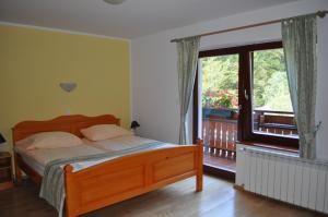 索尔察瓦Prenočišča Valentina的一间卧室设有一张床和一个阳台的窗户。