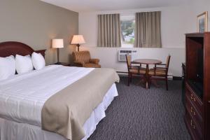 萨德伯里Rodeway Inn的酒店客房设有一张大床和一张桌子。