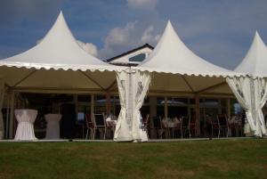 赖讷莱茵博物馆高尔夫酒店的白色帐篷下配有桌椅
