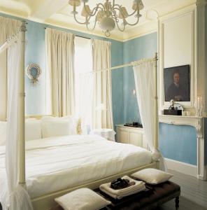 波佩林赫雷阔酒店的卧室配有白色床和吊灯