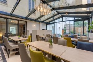 巴黎维利尔花园酒店的餐厅设有桌椅和窗户。
