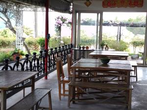 Yung-an-ts'un高台民宿的餐厅设有木桌、椅子和窗户。
