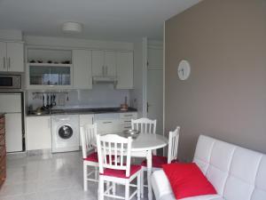 波尔托辛Apartamento Portosín的厨房配有白色的桌椅和白色的沙发