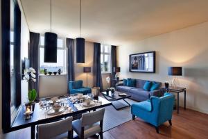 里斯本里斯本五星公寓 - 8号楼的客厅配有桌子和蓝色椅子