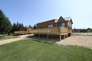 EdgertonLakeland RV Campground Loft Cabin 1的大型木制房屋设有门廊和甲板