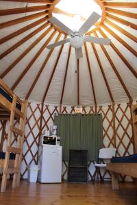 斯特金贝Tranquil Timbers Yurt 3的蒙古包内的吊扇和冰箱