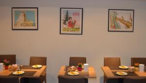 库尔Central Hotel Post的用餐室配有桌椅,墙上挂有图片